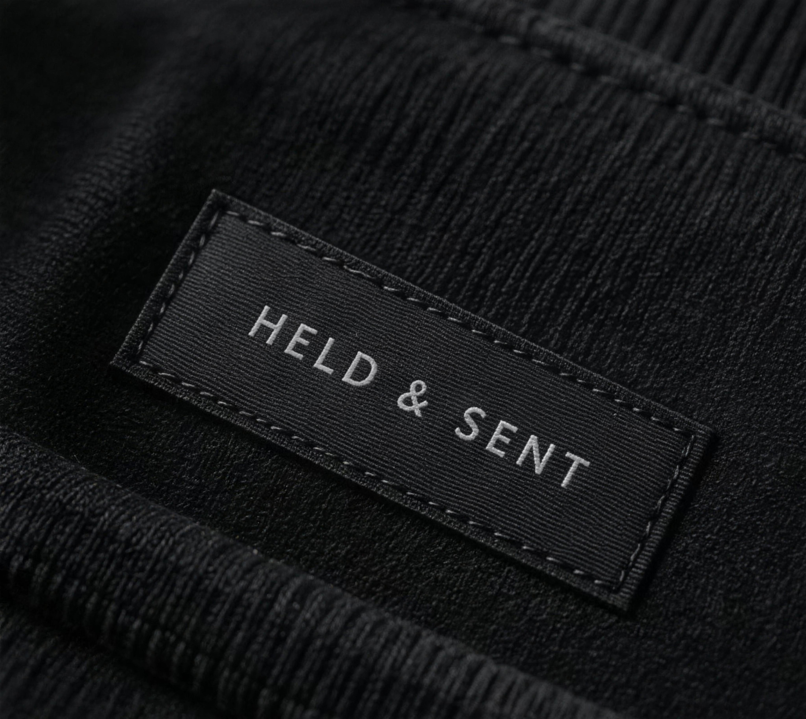 A woven HELD & SENT label stitched into the hem of a fleece