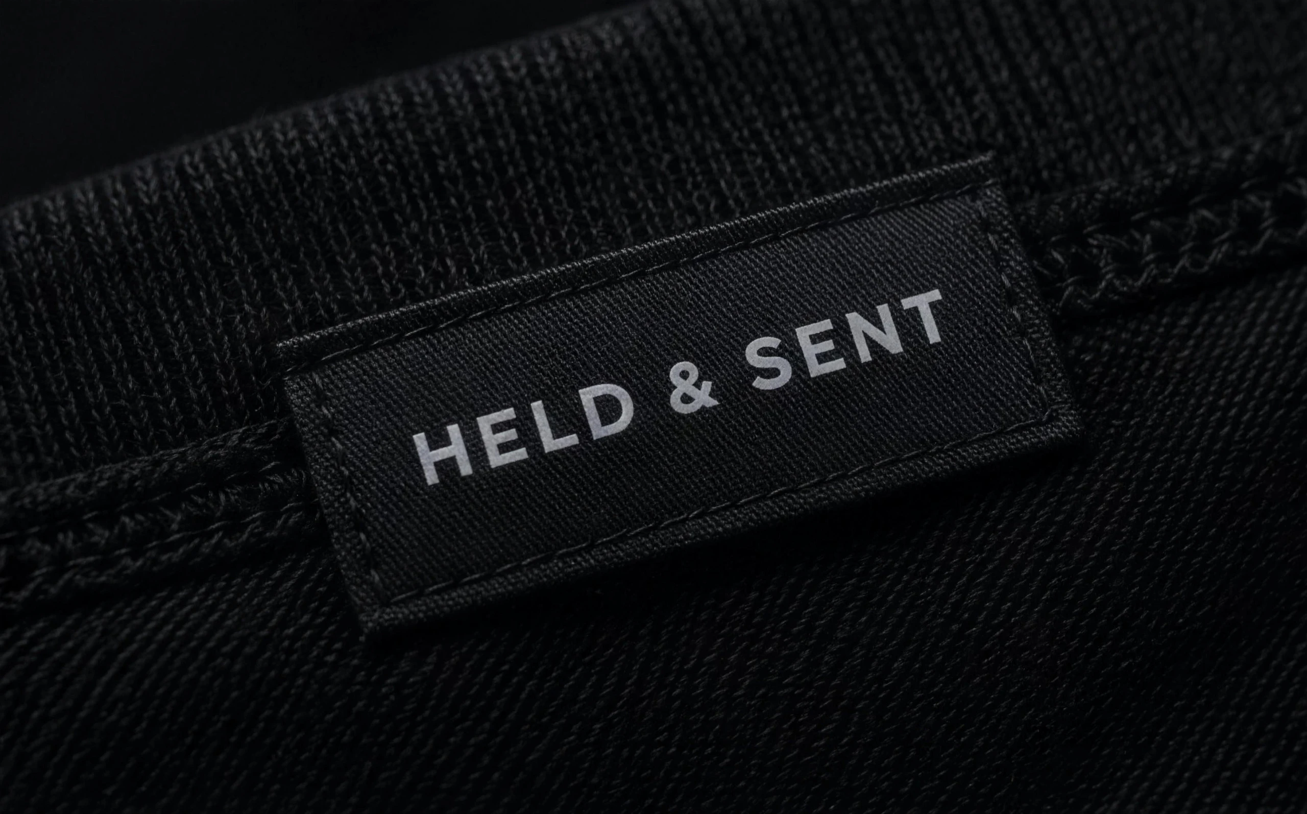 Woven HELD & SENT label stitched into a ribbed collar