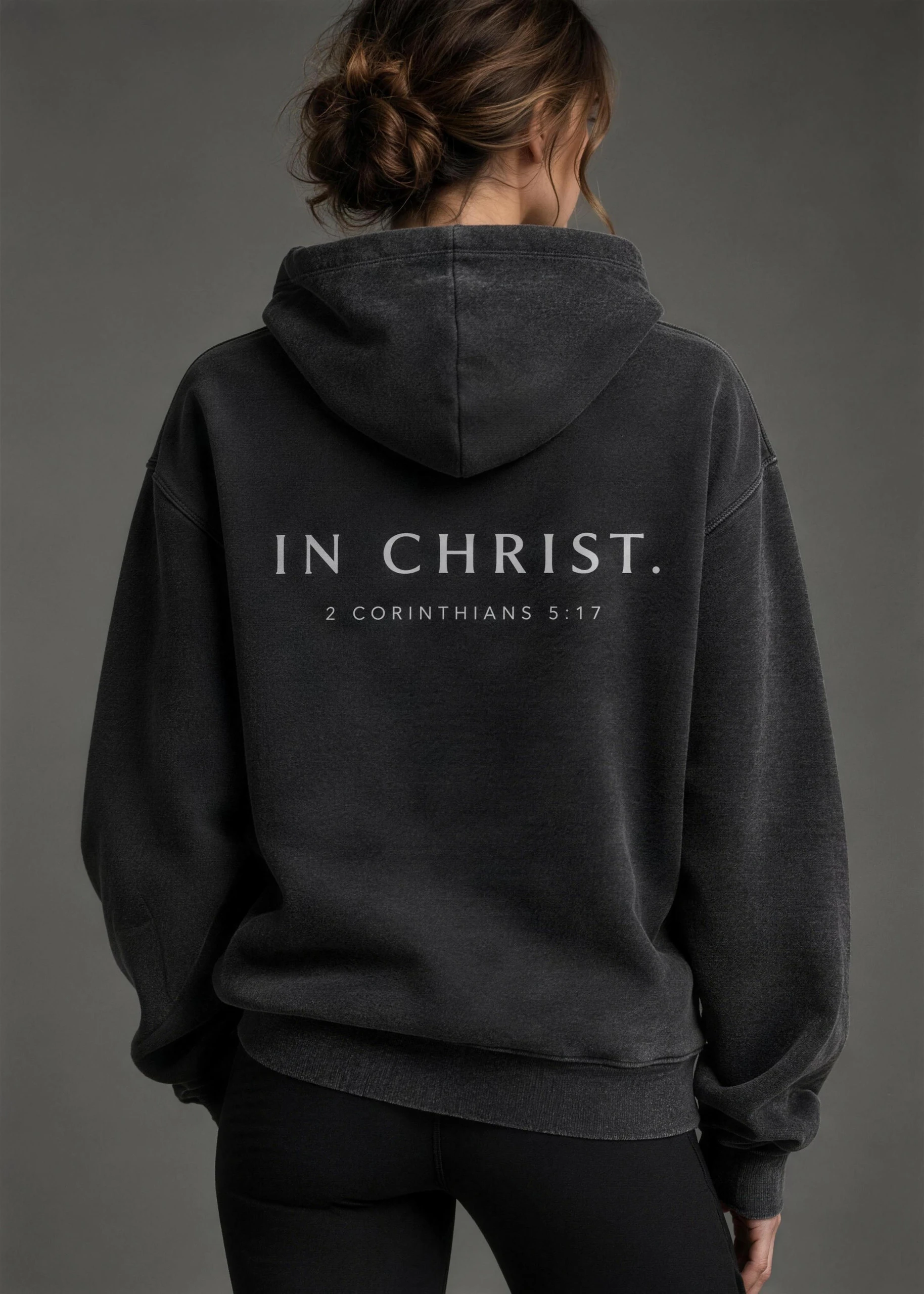 IN CHRIST printed across the back of a washed hoodie